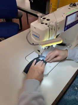 une couturière s'affaire à la fabrication d'un porte-monnaie upcyclé