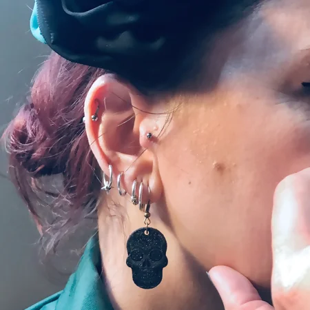 Boucles d'oreilles upcyclées gros plan sur une boucle d'oreilles portées par un jeune femme